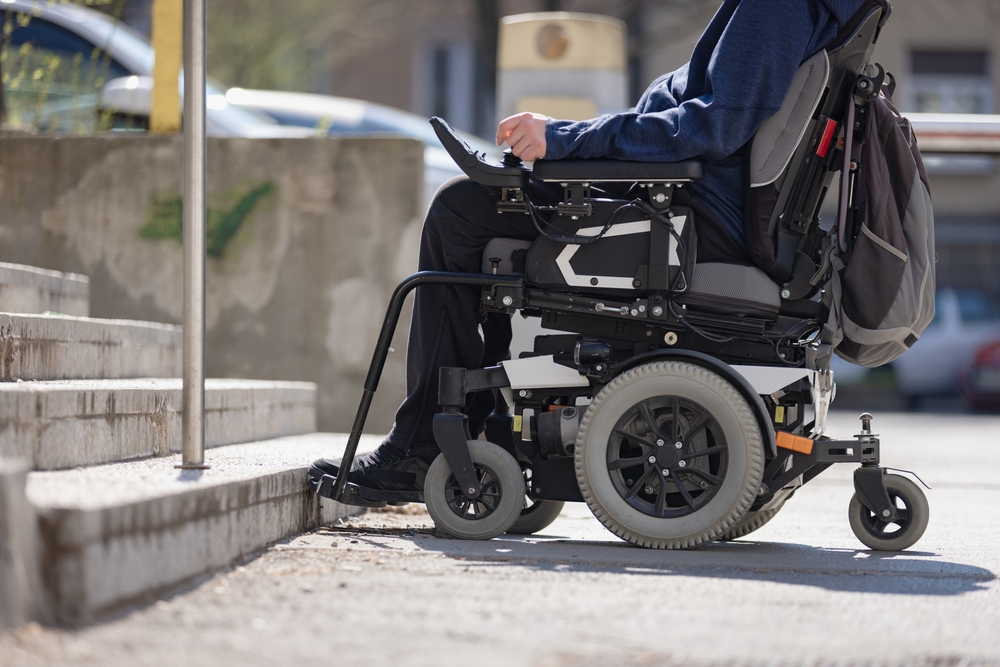 Man,With,Disability,On,Wheelchair,Stopped,In,Front,Of,Staircase,